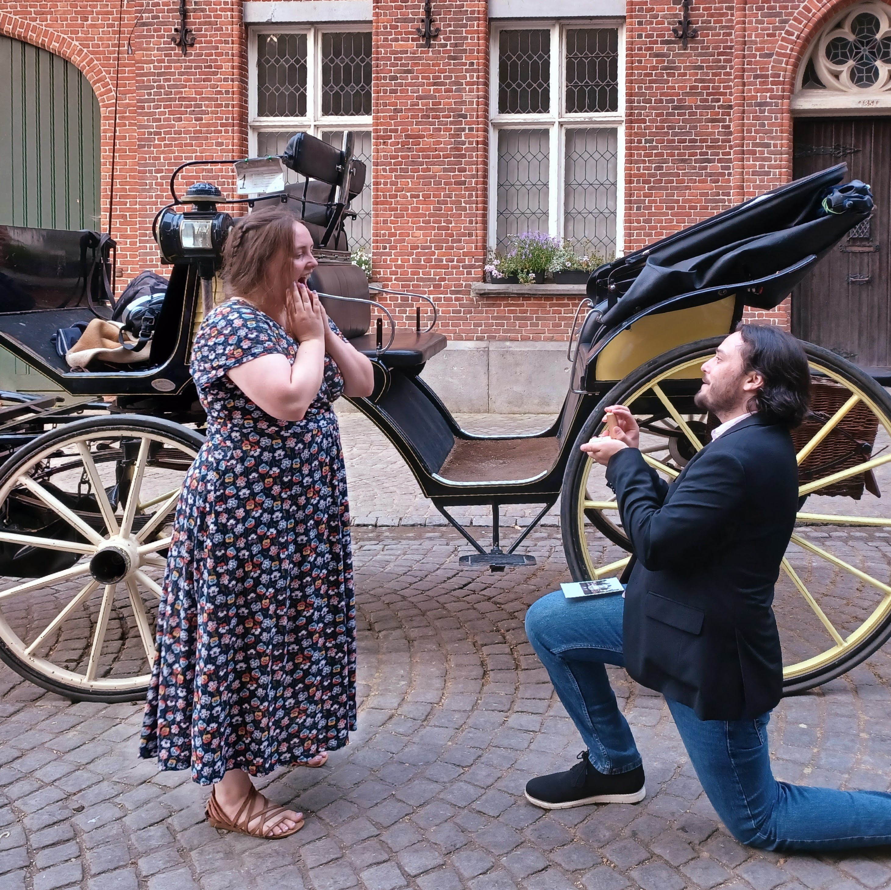 Max gets down on one knee for Kirsten, who is shocked to see a ring inside the ring box Max is holding open.
